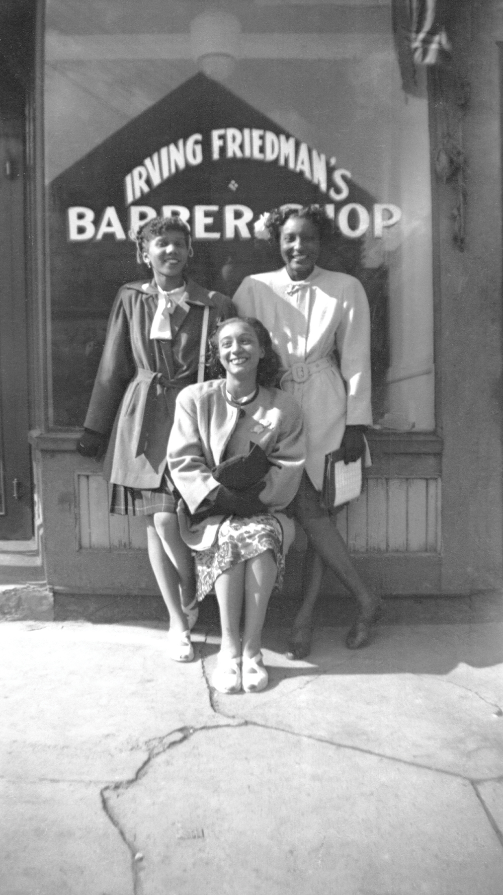 Pictured (left to right): Doris Dunham, Gloria Rohadfox, and Evelyn Branch in front of Irving Friedman’s barbershop.
