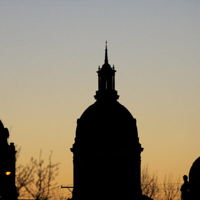 Several buildings and monuments silhouetted against the early morning sky in Wichita, Kansas.
